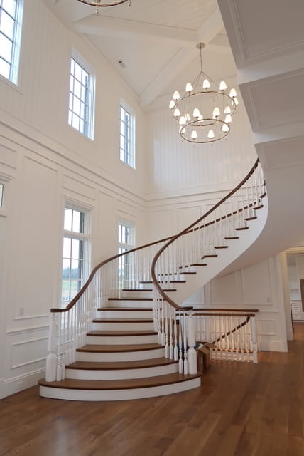 curved staircase luxury Nashville foyer with bowed treads, and antique reproduction newels